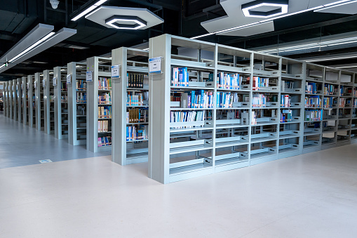 centered point of view of an aisle of books inside a library