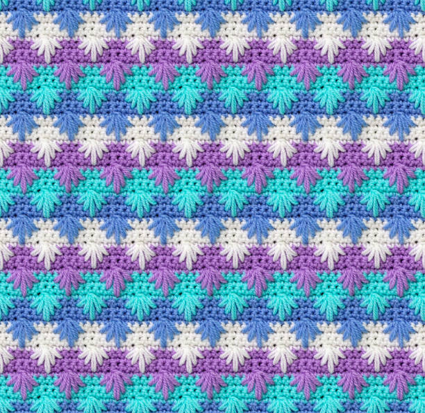istock Seamless knitted texture. The pattern in the form of snowflakes is crocheted from colored acrylic yarn. 1448116714