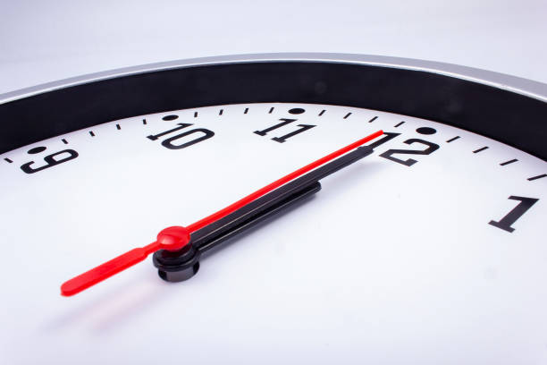 istock Midnight is coming. Black and white office clock with a red pointer on a gray background. 1448116999