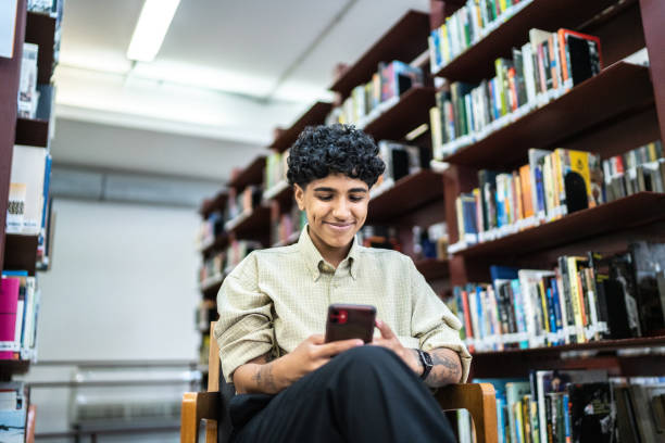 Young woman using the mobile phone in the library