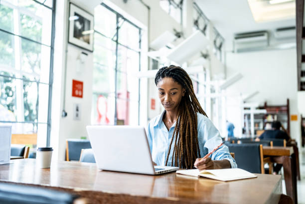 istock Young woman using the laptop in the library 1448117654