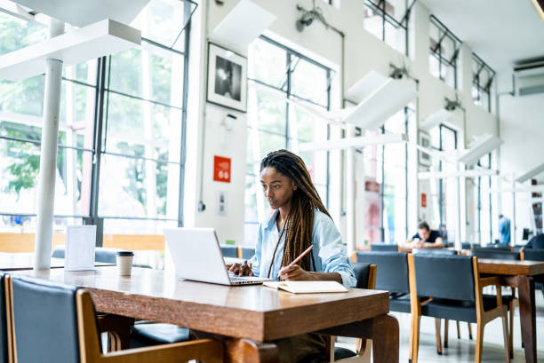 istock Young woman using the laptop in the library 1448117657