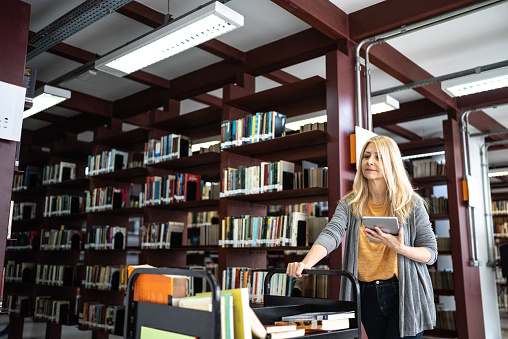 Librarian putting books back in the library