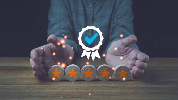 istock Quality Assurance Symbol Icon on Wood Cube and 5 Star Certification, Standard, Customer Satisfaction Guarantee, ISO Businessman holding and showing the best quality assurance with golden five stars. 1448118118