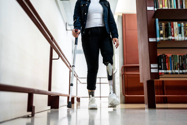 Low section of a disabled woman walking in the library