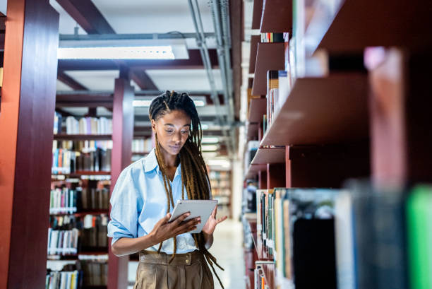 Young woman using the digital tablet in the library Young woman using the digital tablet in the library bookstore stock pictures, royalty-free photos & images