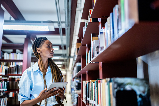 Young woman searching books in the library