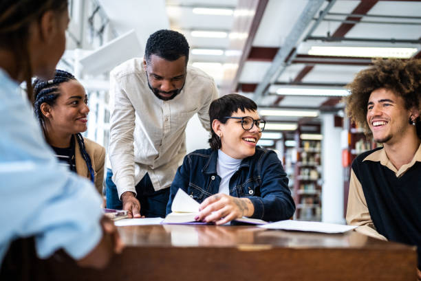 istock Teacher helping students in the library - including transgender woman 1448121835