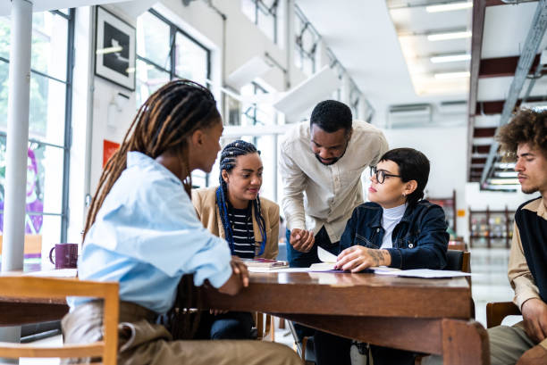 istock Teacher helping students in the library - including transgender woman 1448121861