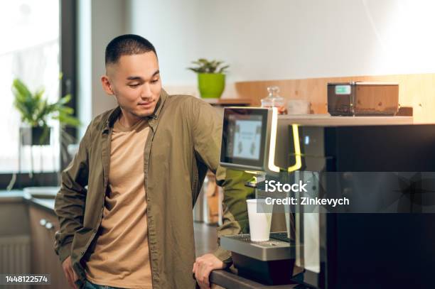 Company Employee Preparing A Caffeinated Beverage At Work Stock Photo - Download Image Now