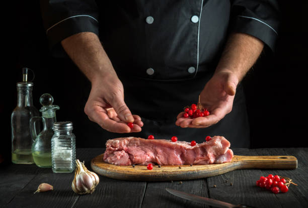 istock In the restaurant kitchen chef prepares raw calf meat. Before baking, the cook puts the viburnum on the beef. National dish 1448123286