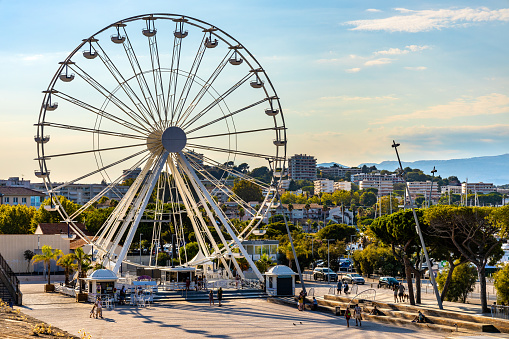 Antibes, France - August 4, 2022: Grand Ferris Wheel Grande Roue at Esplanade du Pre des Pecheurs promenade in Vauban Port and yacht marina onshore Antibes harbor