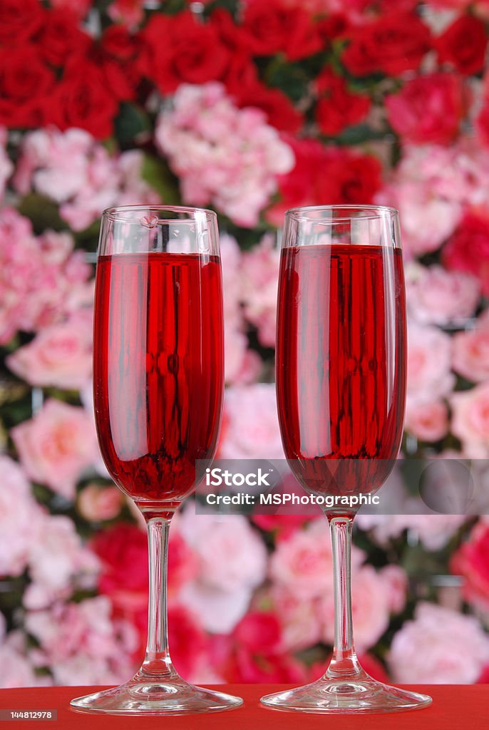 Romance Two glasses of red wine in front of a wall of roses Alcohol - Drink Stock Photo