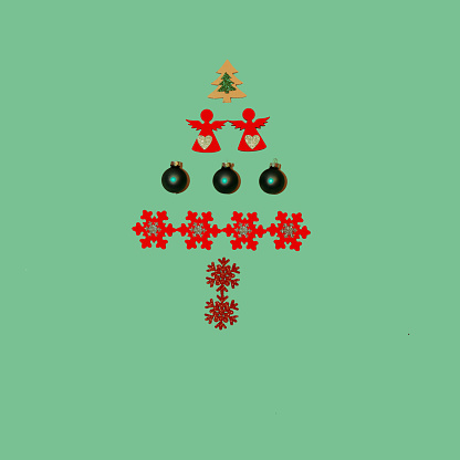 Christmas tree made of decorative ornaments  a green background. Christmas theme. Flat lay concept.