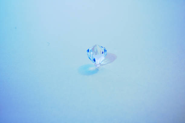 Shimmering  gemstone held in tweezers