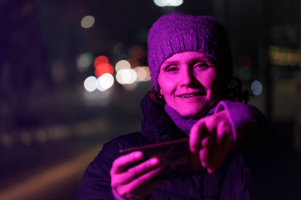 istock woman playing on mobile phone in outdoor setting, at evening 1448142125