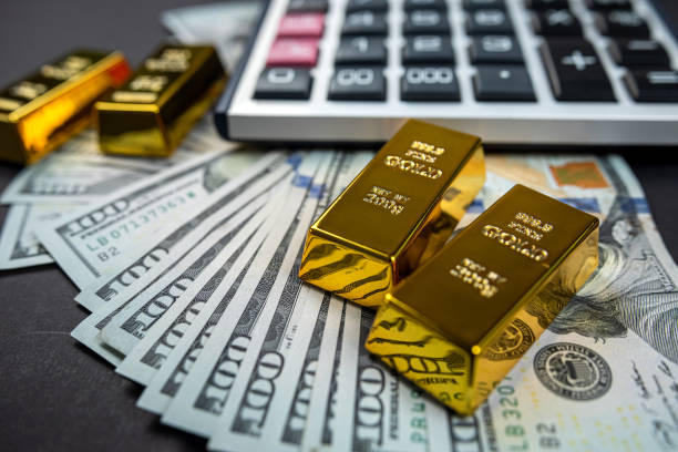 istock Gold ingots on American dollar banknotes close-up isolated on plain background. 1448148803