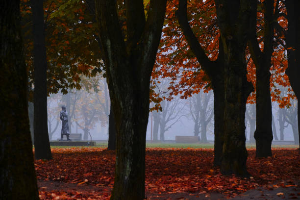 Public autumn park with chestnut trees and falling orange foliage