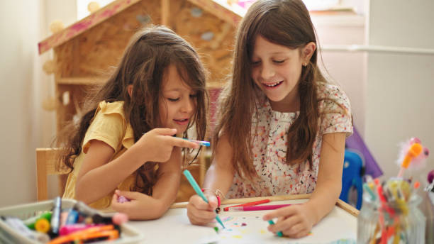 istock Sisters at home drawing and painting together 1448153878