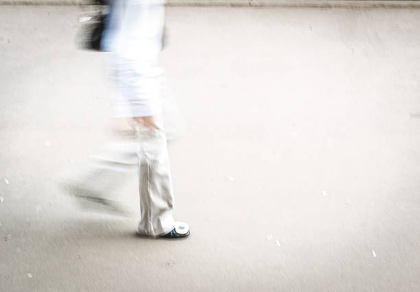 istock woman white dressed walking street, blurry motion 1448153986