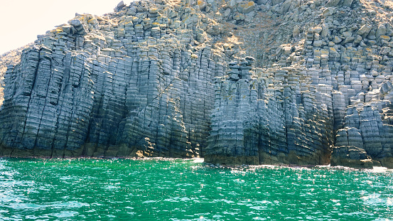 rocky mountain formations stacked on top of each other by the sea, formed by a volcanic eruption. The volcanic rock formations along the sea strip on Imbros island of Gökçeada are called Cheese cliffs. Canakkale Turkey