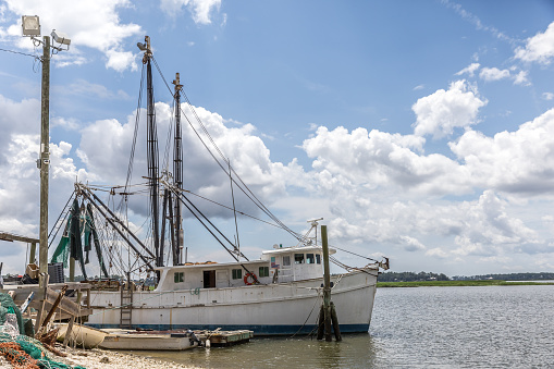 A view of coastal Bluffton South Carolina in the daytime with a fishing boat at the pier.