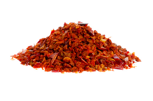 Paprika red pepper isolated on white background. Heap of crushed red pepper isolated on white background. Pieces of red pepper isolated on white background. Paprika isolated on white background