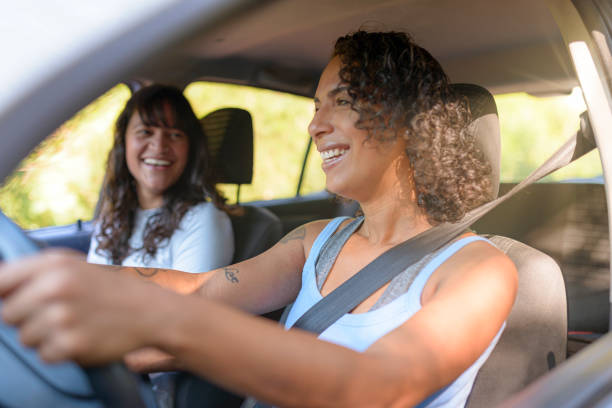istock Young women friends inside car going out to trip 1448155363