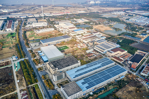 A bird's-eye view of a factory building by the highway in Shanghai, the roof is covered with solar panels