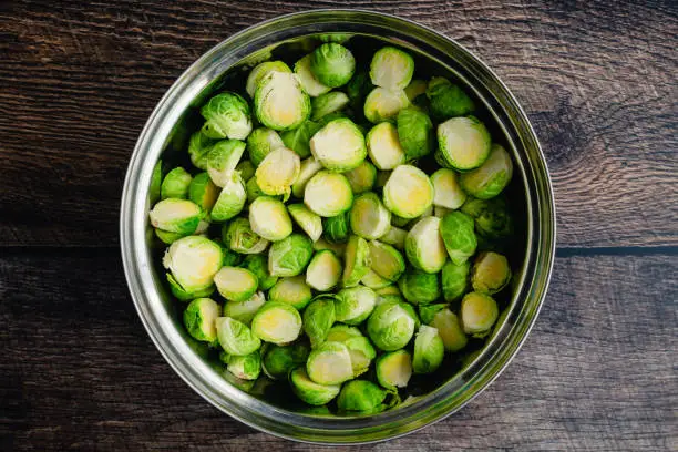 Uncooked Brussels sprouts tossed in a metal mixing bowl