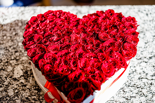The decoration is made from roses in the shape of a heart in a paper box.