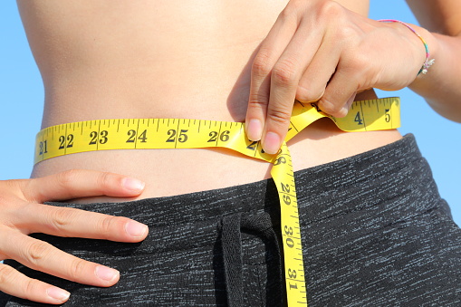 young girl belly waist measurement with yellow tape measure and inch measure