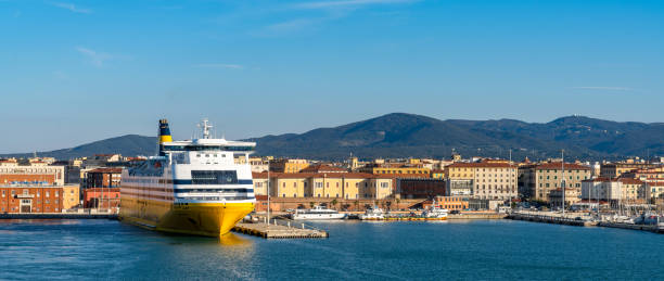 large passenger ferry in the port of Livorno with the old town and waterfront behind Livorno, Italy - 1 December, 2022: large passenger ferry in the port of Livorno with the old town and waterfront behind livorno stock pictures, royalty-free photos & images