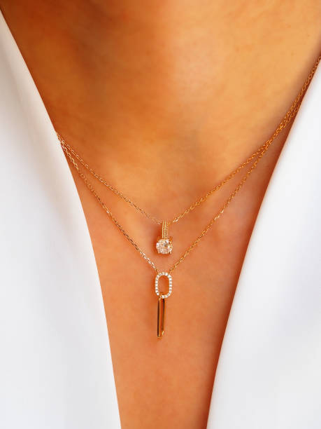 Gold diamond Necklaces accumulation on a woman neck wearing a white jacket stock photo