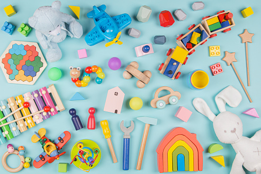 Baby kids toys pattern. Set of colorful educational wooden and fluffy toys on light blue background. Top view, flat lay.