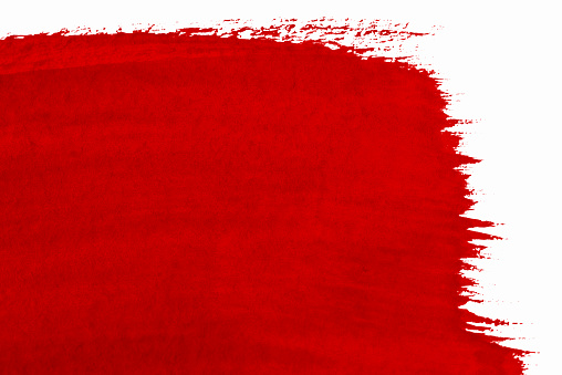 Red paint stroke on a white textured paper. Space for copy.