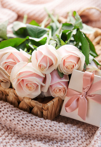 Tray with  bouquet of beautiful pink roses and gift box on  bed. Valentines day concept.