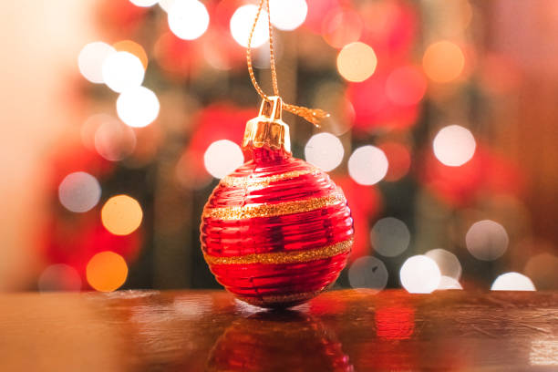 istock Christmas ball close-up with background lights and christmas tree. 1448175109