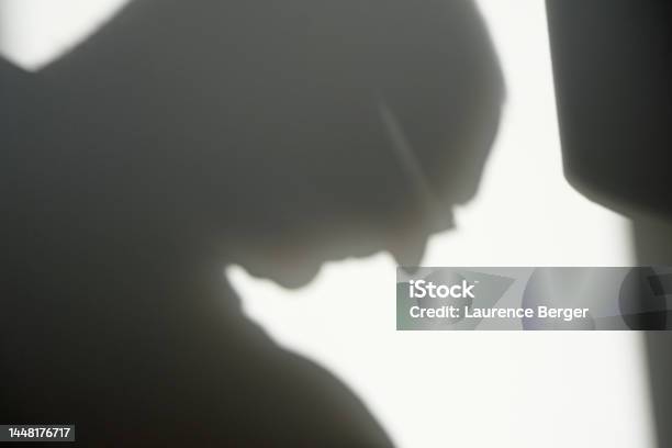 Sunlit Shadow Of A Mature Adult Male Head Bowed Stock Photo - Download Image Now - Adult, Adults Only, Color Image