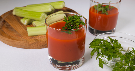 Glasses of tomato juice on a white table. Healthy and vegetarian food concept