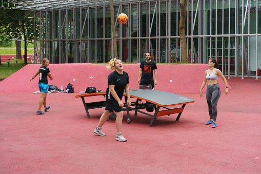 Moscow, Russia - July 13, 2020: People play teqball on the playground, It's very popular modern game. Healthy lifestyle concept. The ball flies in an unpredictable trajectory over a curved table