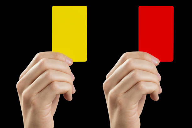 istock Referee hand holding yellow and red cards on black 1448187788