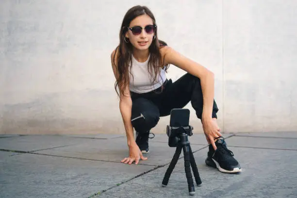 Photo of Young influencer filming a dance video for social media with a smartphone