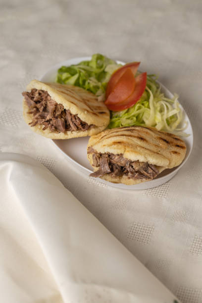 istock Arepas, typical Venezuelan food, made with maize and filled with shredded meat with copy space. 1448192821