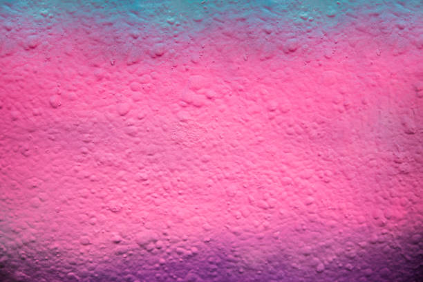 A close up image of a blue, pink and purple spray painted textured bumpy wall to use as a background.