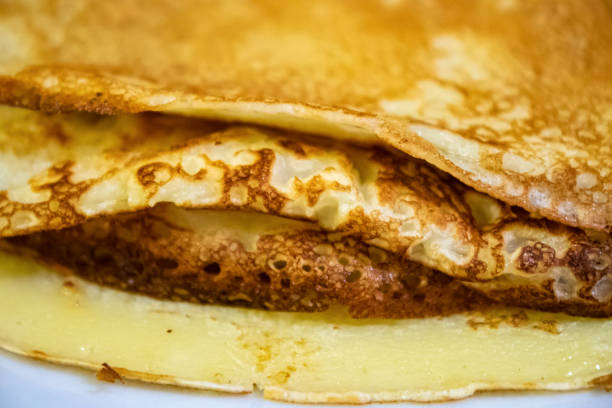 Pancakes of two sizes stacked on plates and placed on table