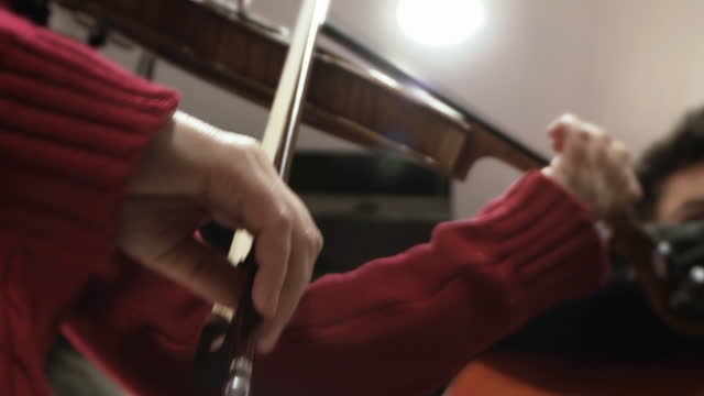 A Woman plays the Violin while Rehearsing with her Traditional Argentine Tango Band. Close Up. Low Angle View. 4K Resolution.