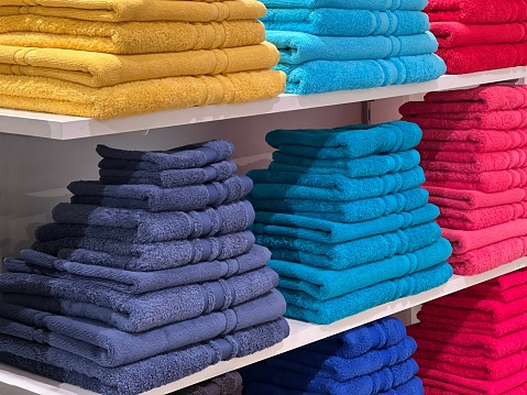 Towel stack of colorful towels in the shelves.