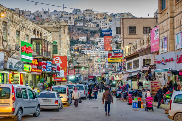 Pedestrians walk on a shopping street in downtown Nablus Palestine in the evening.