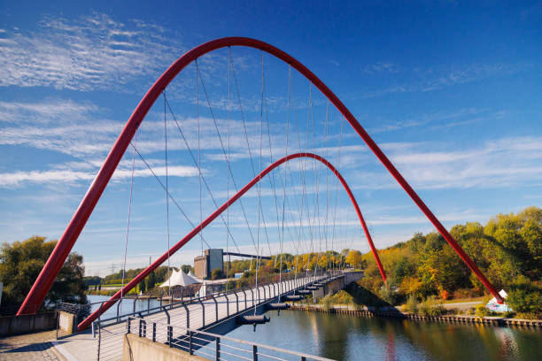 Wide view of beautiful red bridge to the Nordstern Park, Schurenbachhalde near Essen, Germany.